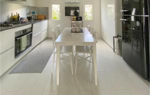 une cuisine avec une table blanche au milieu dans l'établissement 3 Bedroom Lovely Home In Eldsberga, à Eldsberga