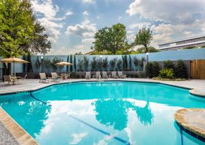 a swimming pool with chairs and a fence at DoubleTree by Hilton Austin Northwest - Arboretum in Austin