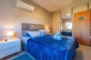 a bedroom with a bed with a blue comforter at Bem localizado - @stayhousetemporada in Canela
