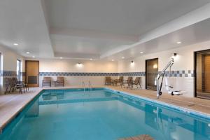 a pool in a hotel with chairs and tables at Hampton Inn & Suites Birmingham Airport Area in Birmingham