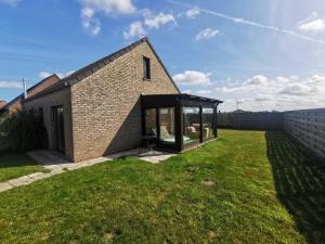 a brick house with a glass extension at Izzy's Rainbow House in De Haan