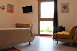 - une chambre avec un lit, une fenêtre et une chaise dans l'établissement Giobo Rooms, à Siniscola