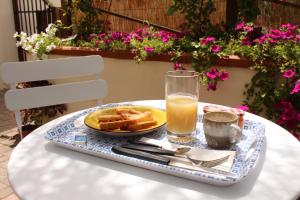 une table avec une assiette de gaufres et un verre de jus d'orange dans l'établissement Giobo Rooms, à Siniscola
