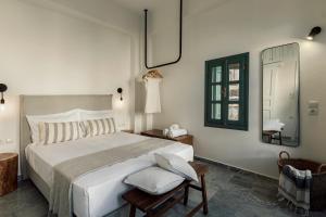 una camera da letto con un grande letto bianco e uno specchio di Soleil boutique house with terrace a Rethymno