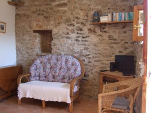 a living room with a chair and a tv at Casita Joya in Perelló