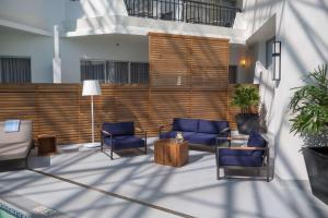 a lobby with two blue chairs and a wooden wall at Hilton Boston Woburn in Woburn