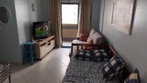 a living room with a tv and a couch at Praia Grande, Canto do Forte, Apto ,2 noites seguidas , apenas 2 diárias com Wi-Fi in Praia Grande