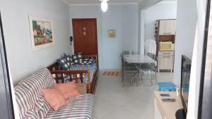 a living room with a couch and a dining room at Praia Grande, Canto do Forte, Apto ,2 noites seguidas , apenas 2 diárias com Wi-Fi in Praia Grande