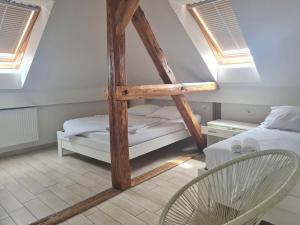 um quarto no sótão com uma cama e uma cadeira em AZUR ROOMS LJUBLJANA em Ljubljana