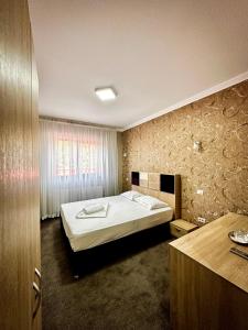 een slaapkamer met een groot bed in een kamer bij Pensiunea Cristal in Racoviţa