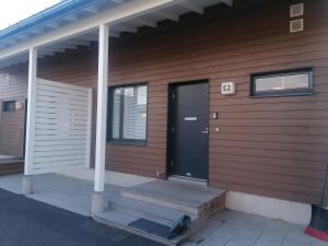 dom z czarnymi drzwiami i werandą w obiekcie Majoituspalvelu Nurmi Apartment Yritysperänkatu 2 E 2 (Centre of Raahe) w mieście Raahe
