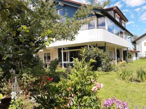 una casa con un jardín delante de ella en Ferienwohnung Pickenhan, en Scheidegg