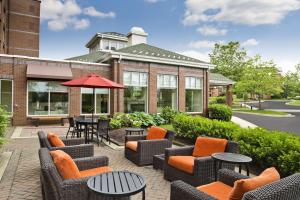a patio with chairs and tables and an umbrella at Hilton Garden Inn White Marsh in White Marsh