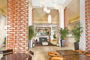 a lobby with tables and chairs and a fireplace at Hilton Garden Inn White Marsh in White Marsh