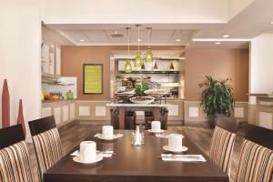 a dining room with a table and a kitchen at Hilton Garden Inn Akron-Canton Airport in North Canton