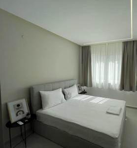 a bedroom with a large white bed with a window at Ladadika Luxury Apartment #4 in Thessaloniki