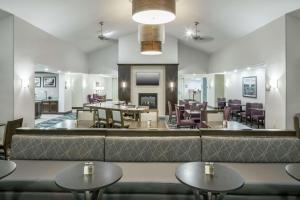a restaurant with tables and chairs and a couch at Homewood Suites by Hilton Cedar Rapids-North in Cedar Rapids