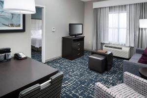 een hotelkamer met een bank en een televisie bij Homewood Suites by Hilton Cedar Rapids-North in Cedar Rapids