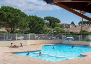 a group of people swimming in a swimming pool at Bastidon paisible dans résidence avec piscine in Fréjus