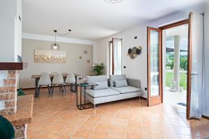 - un salon avec un canapé et une table dans l'établissement VILLA IDA - Regarda Travel, à Costermano