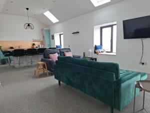 a living room with couches and a flat screen tv at Teach Aindí (newly renovated cottage) in Belmullet