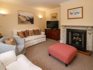 ein Wohnzimmer mit einem Sofa und einem Kamin in der Unterkunft Dinham Court in Ludlow