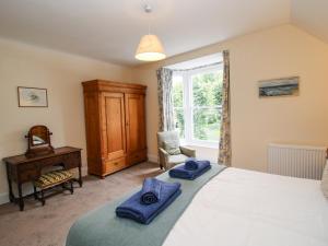 ein Schlafzimmer mit einem Bett mit blauen Handtüchern darauf in der Unterkunft Dinham Court in Ludlow