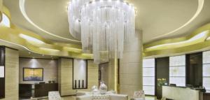 a large chandelier hanging from the ceiling in a lobby at Квартира студия Damac Maison Cour Jardin in Dubai