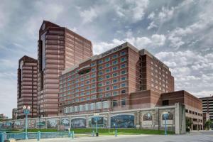 a large brown building with two tall buildings at Embassy Suites Cincinnati - RiverCenter in Covington