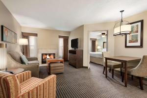 ヒリアードにあるHomewood Suites by Hilton Columbus-Hilliardの暖炉付きのリビングルームが備わるホテルルームです。