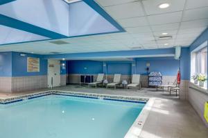 a large swimming pool in a room with blue walls at Embassy Suites Cincinnati - RiverCenter in Covington