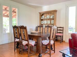 a dining room with a wooden table and chairs at Valansolette in Beynes