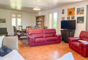 a living room with two red couches and a television at Valansolette in Beynes +11 photos