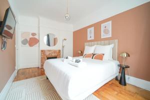 ein Schlafzimmer mit einem großen weißen Bett und einem Kamin in der Unterkunft Apartment next to Louis Vuitton Fondation in Neuilly-sur-Seine