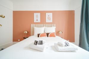 sypialnia z dużym białym łóżkiem i 2 ręcznikami w obiekcie Apartment next to Louis Vuitton Fondation w mieście Neuilly-sur-Seine