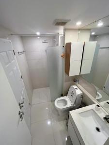 a small bathroom with a toilet and a sink at City center residents Pool view in Pattaya Central
