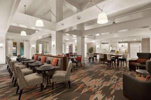 a restaurant with tables and chairs in a room at Homewood Suites Dallas-Addison in Addison