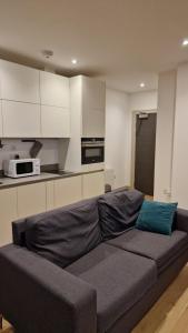 a living room with a couch in a kitchen at London Stadium Apartment in London