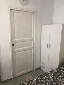 una camera da letto con porta bianca e armadietto bianco di Nido di Puglia 2 a Mola di Bari