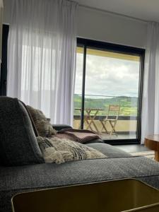 a living room with a couch and a large window at FURNAS DREAM HOUSE in Furnas