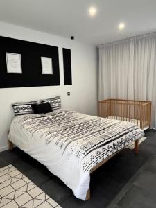 1 dormitorio con 1 cama grande y edredón blanco y negro en FURNAS DREAM HOUSE, en Furnas