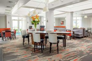 a dining room with tables and chairs and a vase of flowers at Homewood Suites by Hilton Dallas-Irving-Las Colinas in Irving