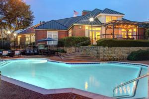a large swimming pool in front of a house at Homewood Suites by Hilton Dallas-Irving-Las Colinas in Irving