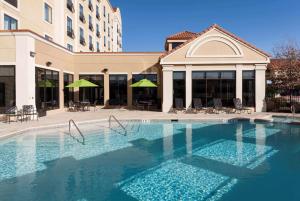 a large swimming pool in front of a building at Hilton Garden Inn Dallas Lewisville in Lewisville
