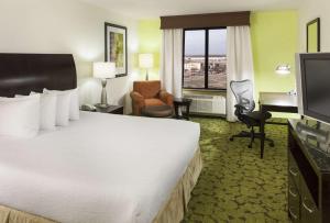 a hotel room with a large bed and a desk at Hilton Garden Inn Dallas Lewisville in Lewisville