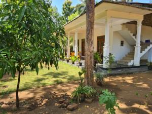 a house with a tree in front of it at Thuruliya Residence in Sigiriya