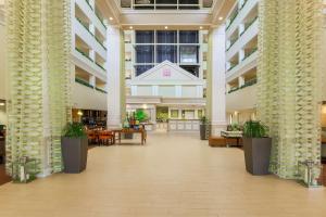 an empty lobby of a building with tables and chairs at Hilton Garden Inn Dallas/Market Center in Dallas