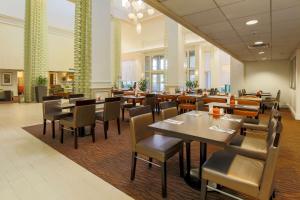 ダラスにあるHilton Garden Inn Dallas/Market Centerのレストラン内のテーブルと椅子のあるダイニングルーム