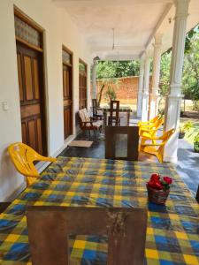 a table with a checkered table cloth on a porch at Thuruliya Residence in Sigiriya