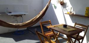 um quarto com uma rede de descanso, uma mesa e cadeiras em Chale Canoa Beach em Canoa Quebrada